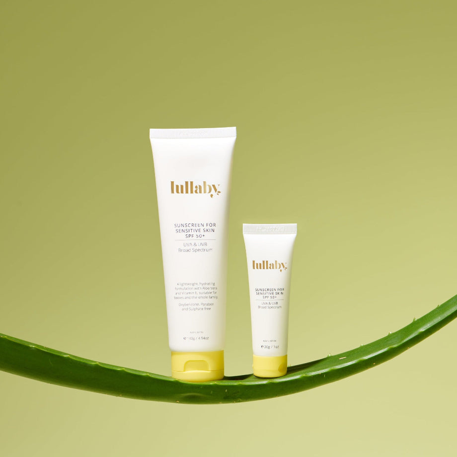 Two tubes of Lullaby skincare product on a green leaf against a light green background