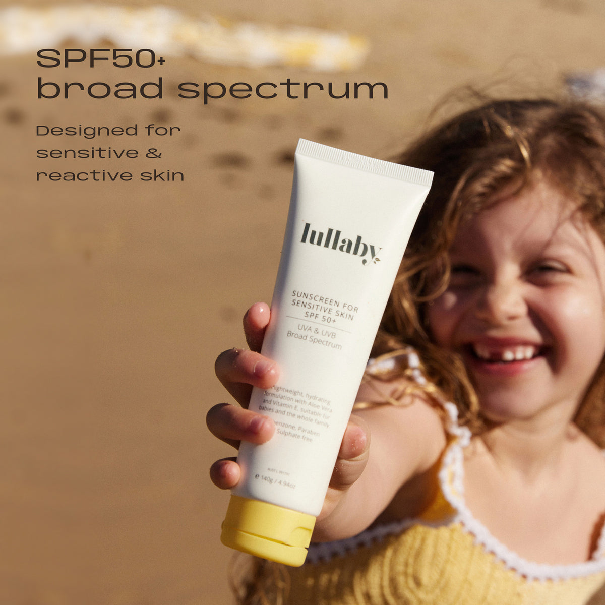 Girl at the beach holding Lullaby SPF50+ Sensitive Skin Sunscreen 140g. SPF50+ broad spectrum, designed for sensitive and reactive skin